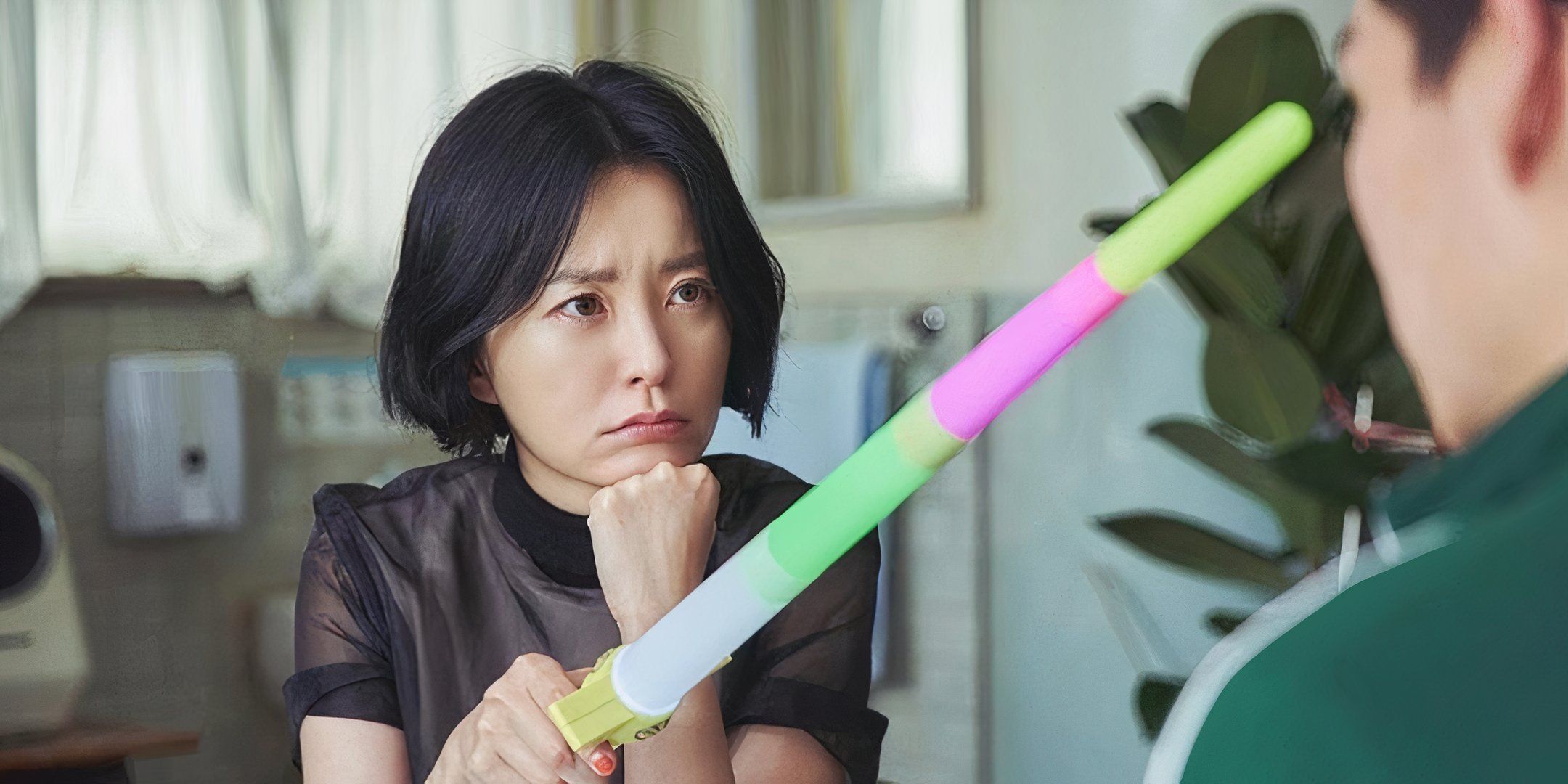 Jung Yu-mi rests her chin on her fist and holds out a colorful stick. 