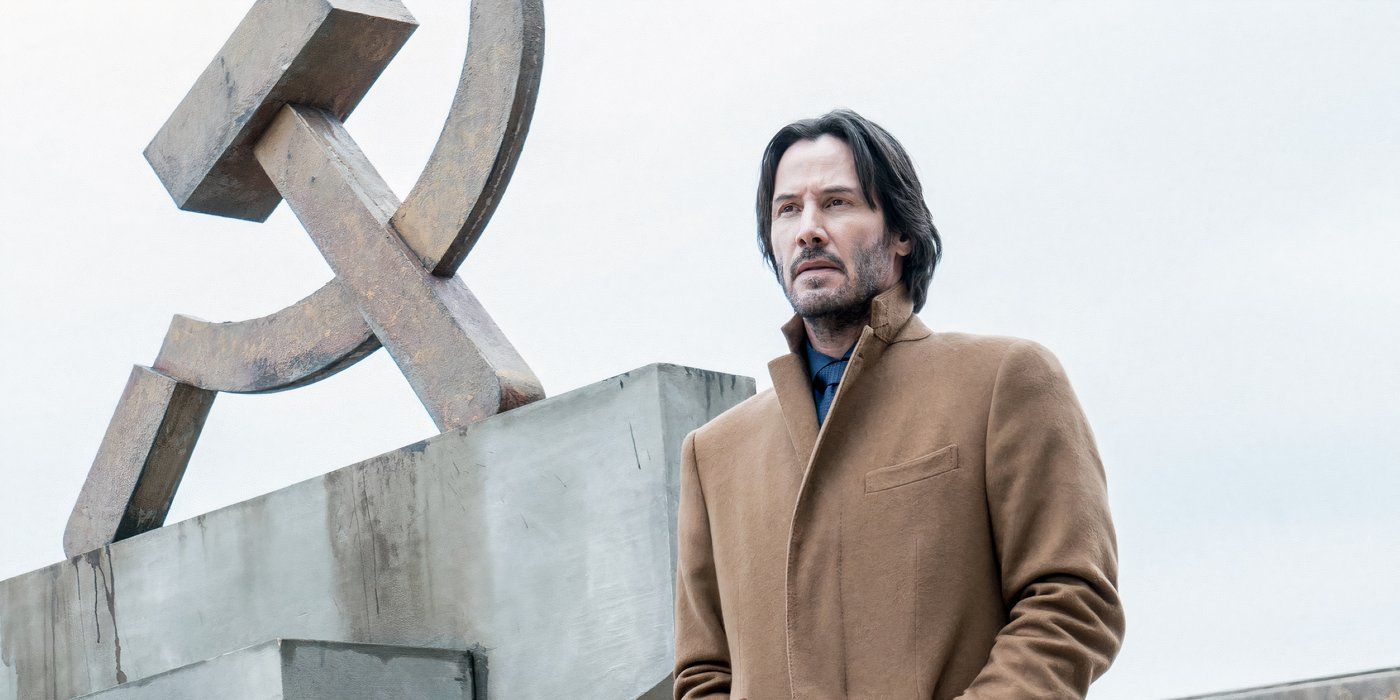 Keanu Reeves in front of a hammer and sickle statue in Siberia 2018