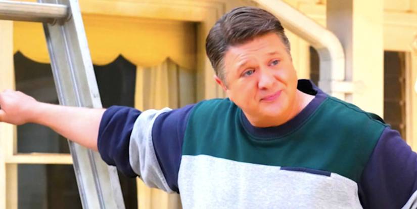 Lance Barber's George Sr looks exasperated as he holds a ladder in Young Sheldon