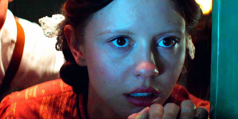 Mia Goth looking fearfully out a window as Pearl in Pearl