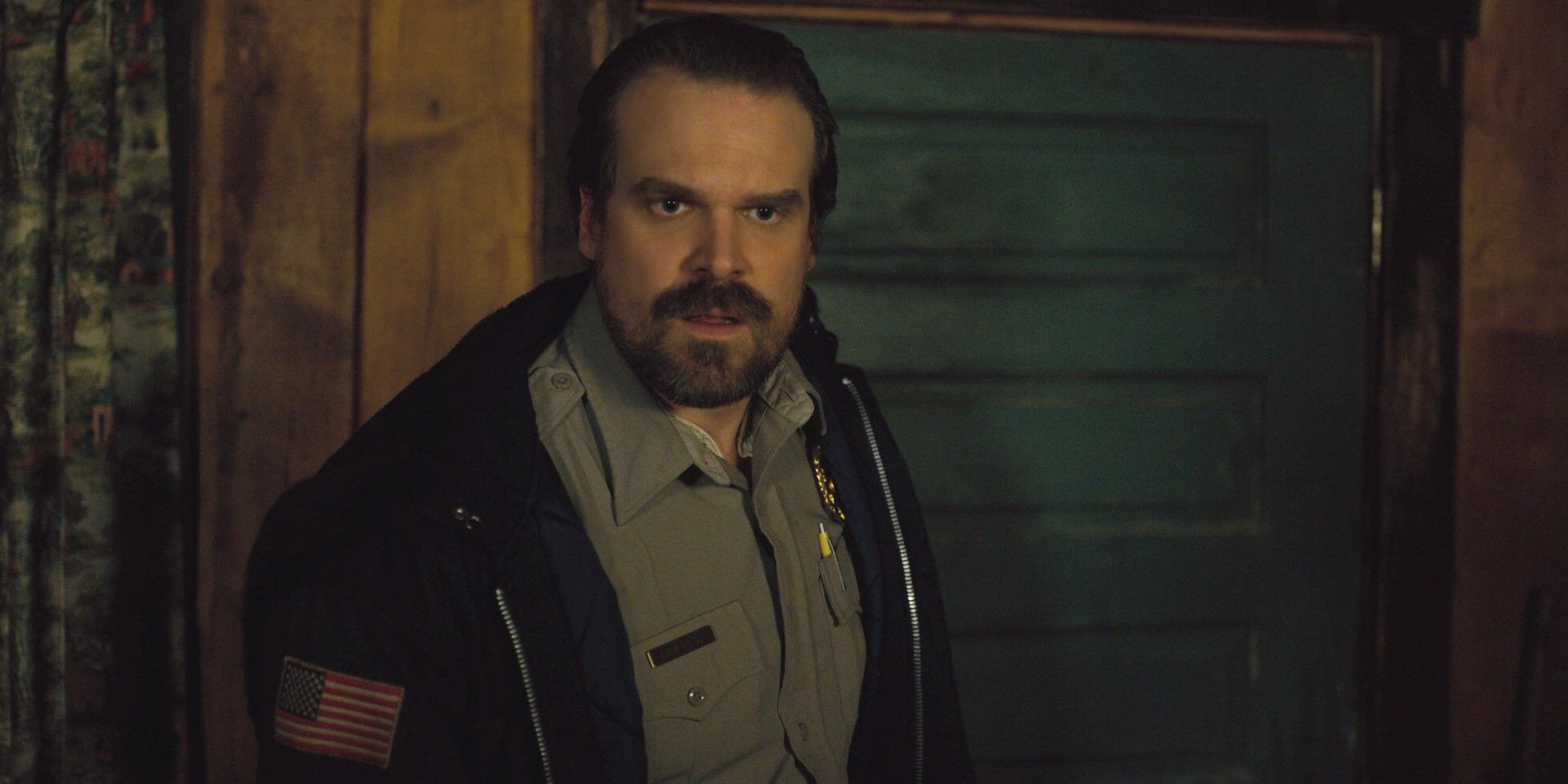 Jim Hopper wearing his uniform and looking annoyed in Stranger Things season 2, episode 8