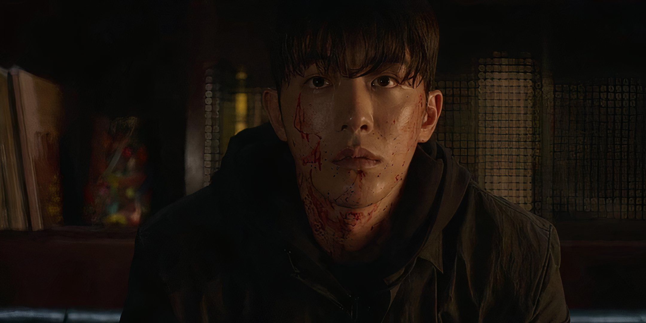 Nam Joo-hyuk stares ahead with blood splattered over his face. 