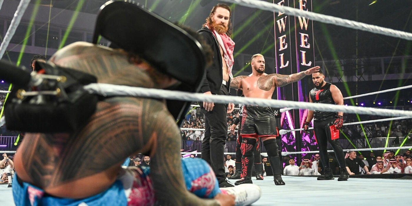 Sami Zayn looks at Jey Uso unconscious alongside Tonga Loa and Solo Sikoa of The Bloodline 2.0 at WWE Crown Jewel 2024