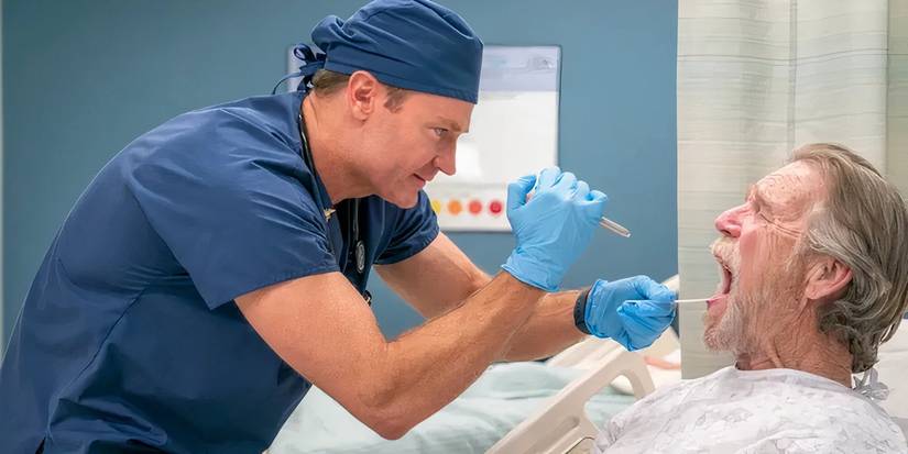 Josh Lawson as a doctor looking into a patient's mouth in St. Denis Medical
