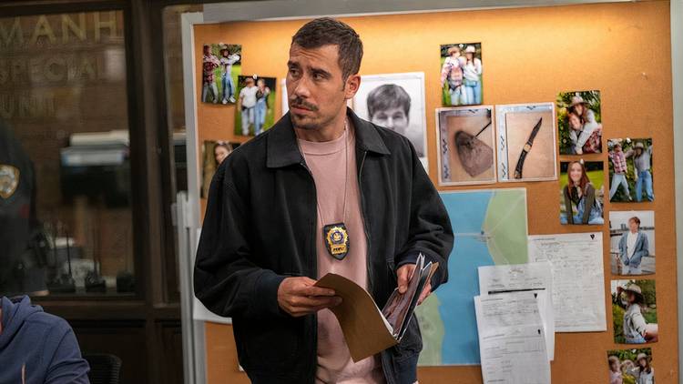 Law & Order: SVU Velasco holding a case file and standing in front of the board