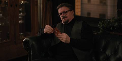 Teddy Dimas holding cards in a flashback in Only Murders in the Building