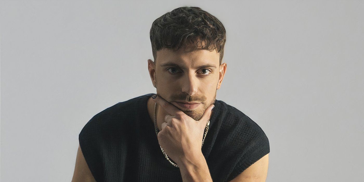  Argentina season 1 Tom Martorello in a black top with a visible chain around his neck while holding his chin with his left hand