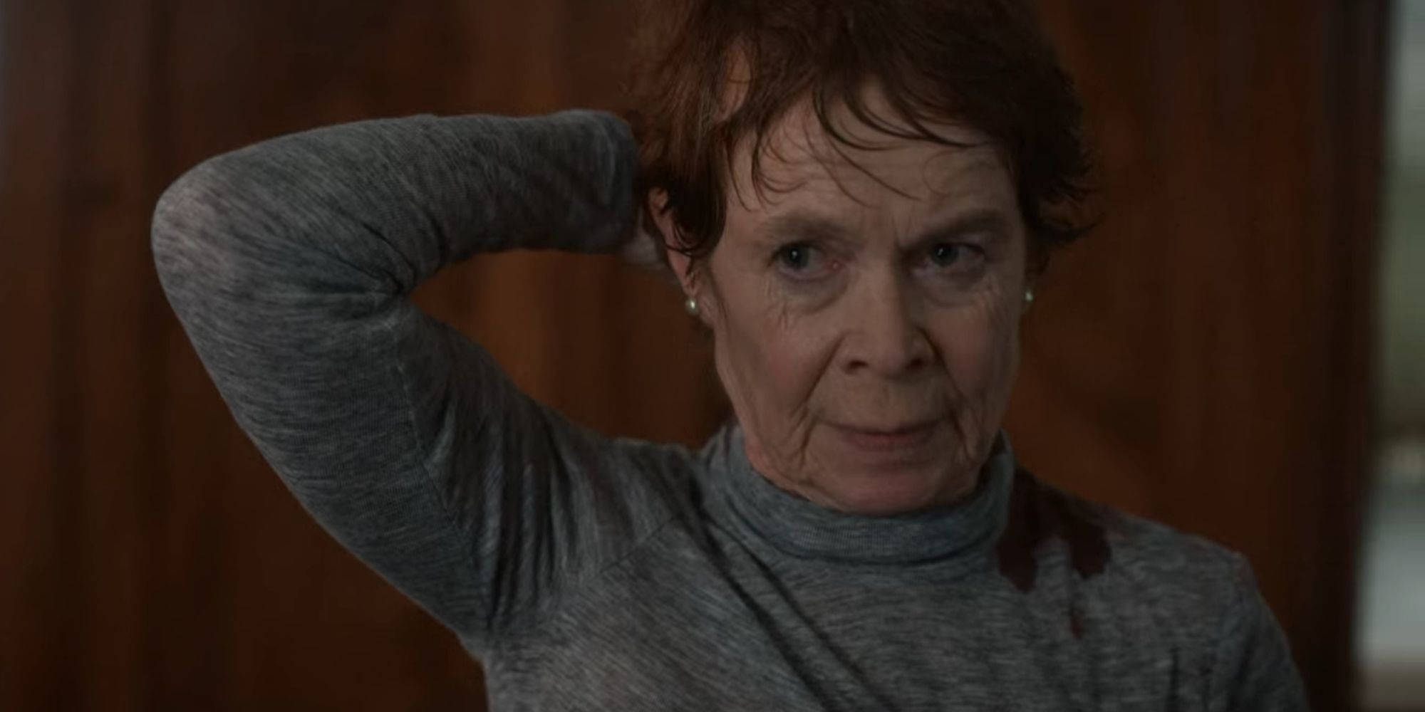 Celia Imrie as Margaret Roylin holding her head in The Diplomat