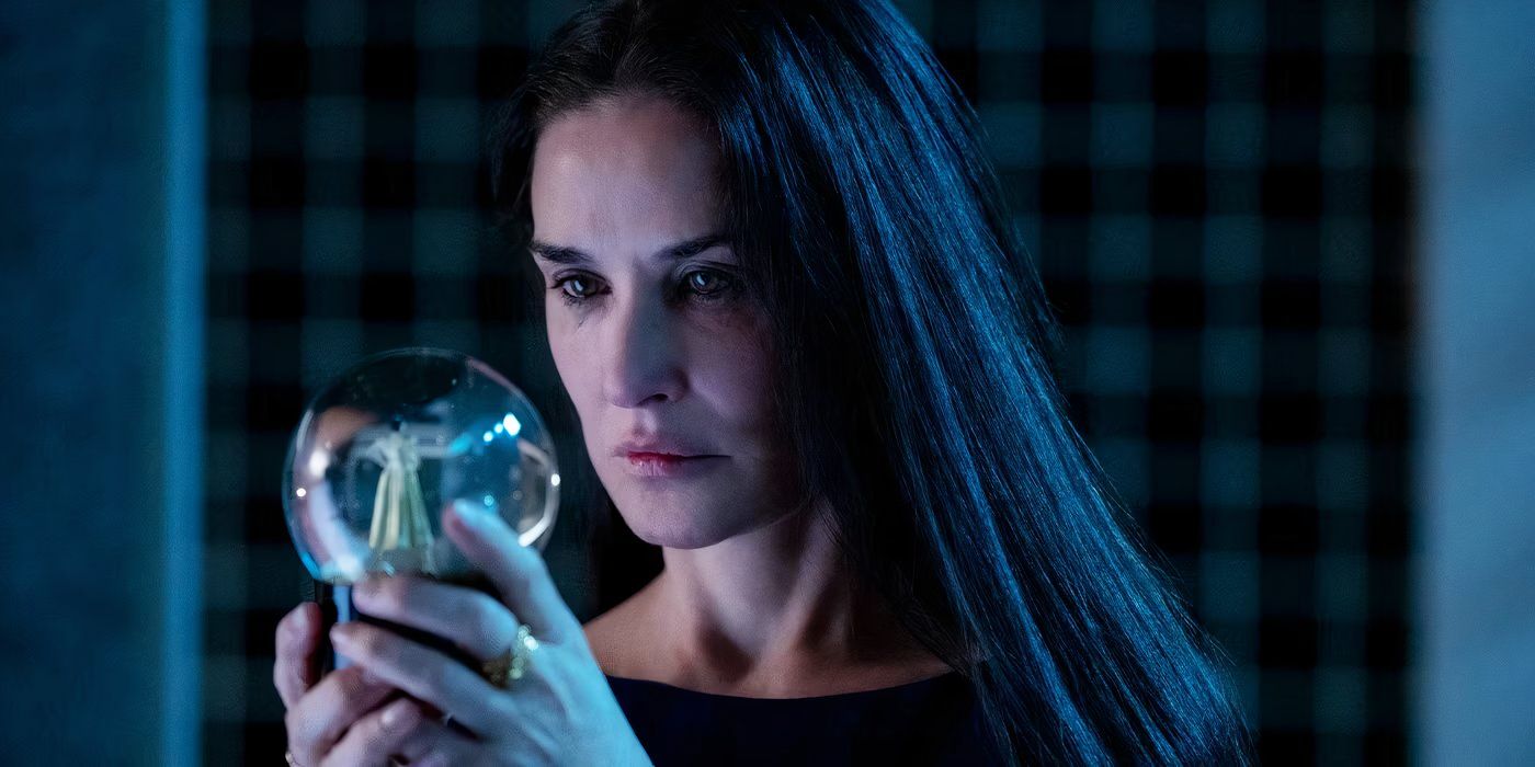 Demi Moore looking at a crystal ball in The Substance