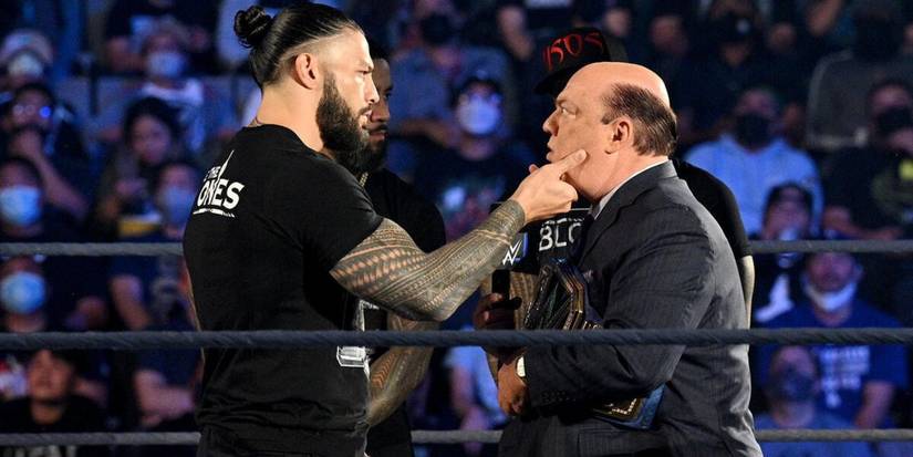 WWE Universal Champion Roman Reigns grabs Paul Heyman by the face in front of The Usos on WWE Friday Night SmackDown