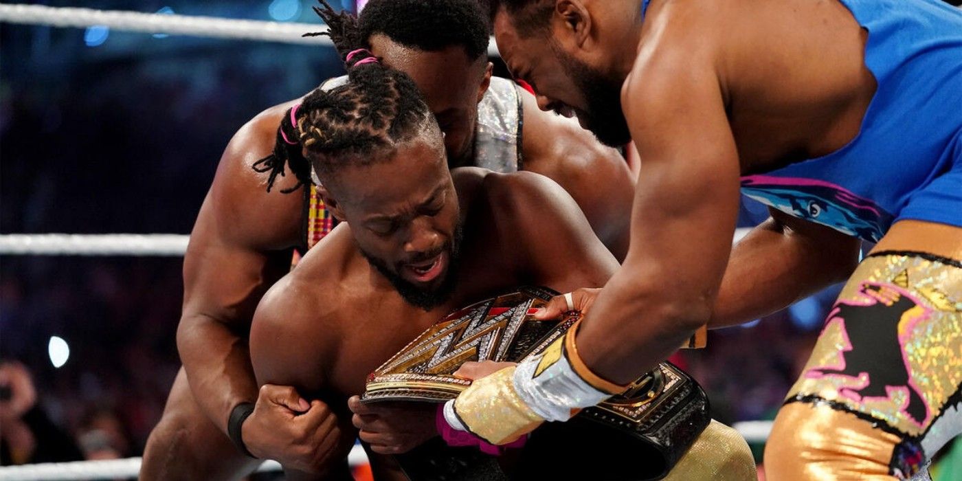 Xavier Woods and Big E hand Kofi Kingston the WWE Championship at WrestleMania 35