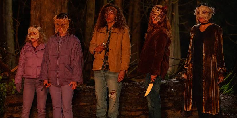Taissa, Van, Lottie, Shauna, and Misty wearing masks and holding knives in Yellowjackets season 2