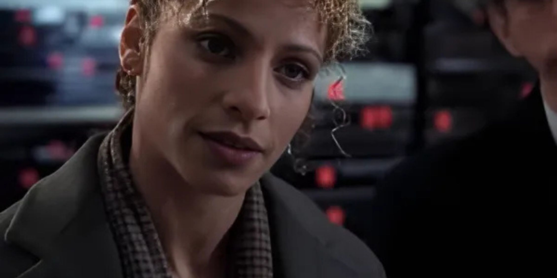 Law & Order: SVU Monique wearing a gray jacket and sitting with her hair up