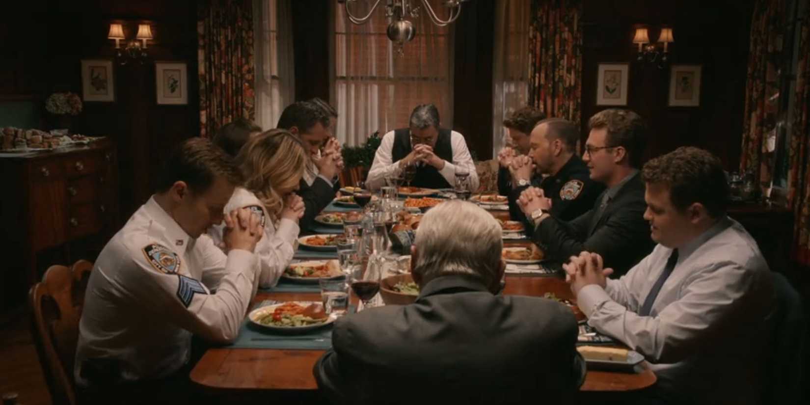 The Reagan family with heads bowed and hands clasped during the final dinner scene