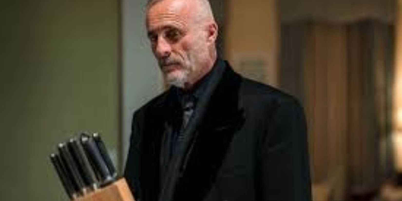 A bad guy looking at a set of knives in Law & Order: Organized Crime