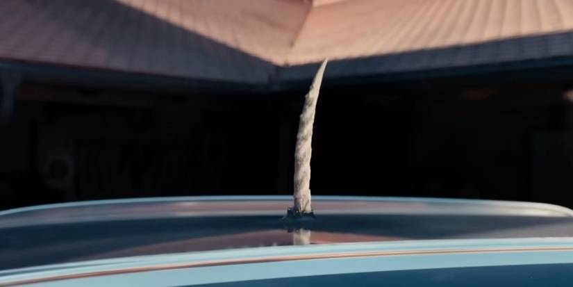 A unicorn horn bursting through the roof of a car in Death of a Unicorn