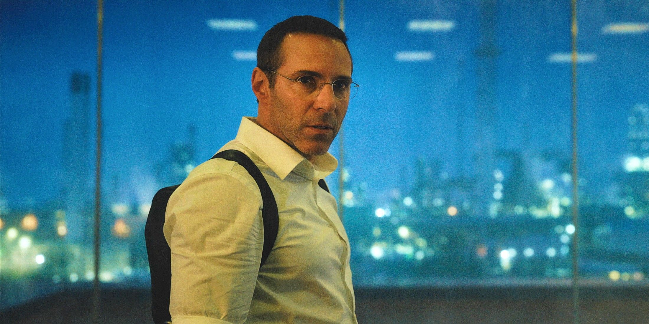 Alessandro Nivola as Aleksei Sytsevich in his office with the London skyline behind him in Kraven the Hunter