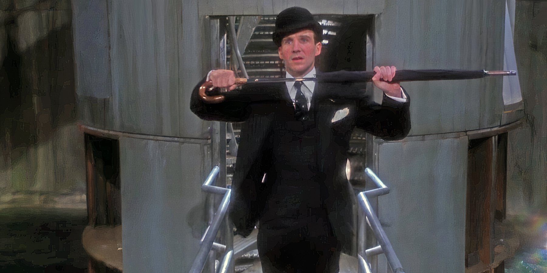 Ralph Fiennes como John Steed puxando uma espada de seu guarda-chuva em Os Vingadores 1998