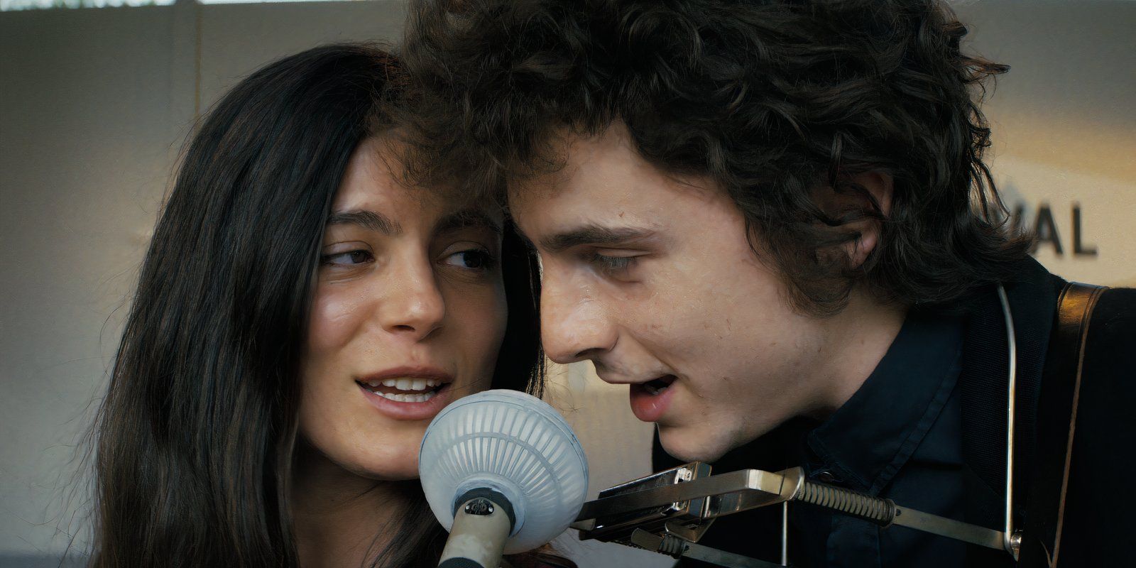 Bob Dylan and Joan Baez sing into a microphone in A Complete Unknown