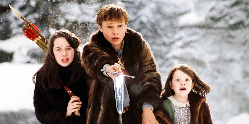Peter, Lucy, and Susan standing together in the snow in Chronicles of Narnia The Lion the Witch and the Wardrobe