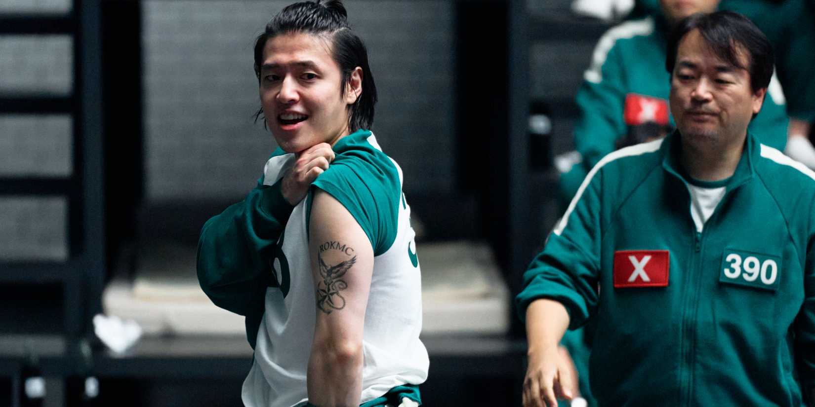 Dae-ho showing off his marine tattoo next to Jung-bae in Squid Game