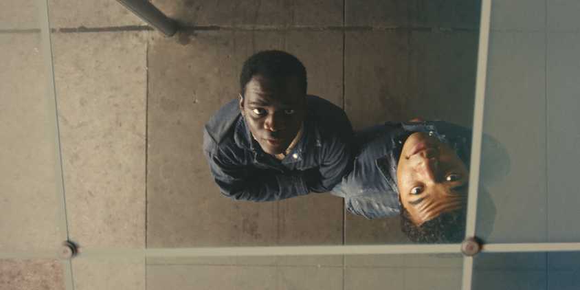 Elwood and Turner looking up at a reflective surface in Nickel Boys