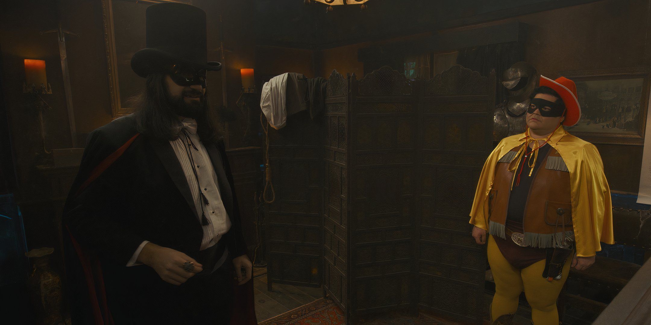 Guillermo, de Harvey Guillén, parecendo chateado em um pequeno terno de cowboy e Nandor, de Kayvan Novak, parecendo animado em um smoking e máscara no final da série What We Do in the Shadows