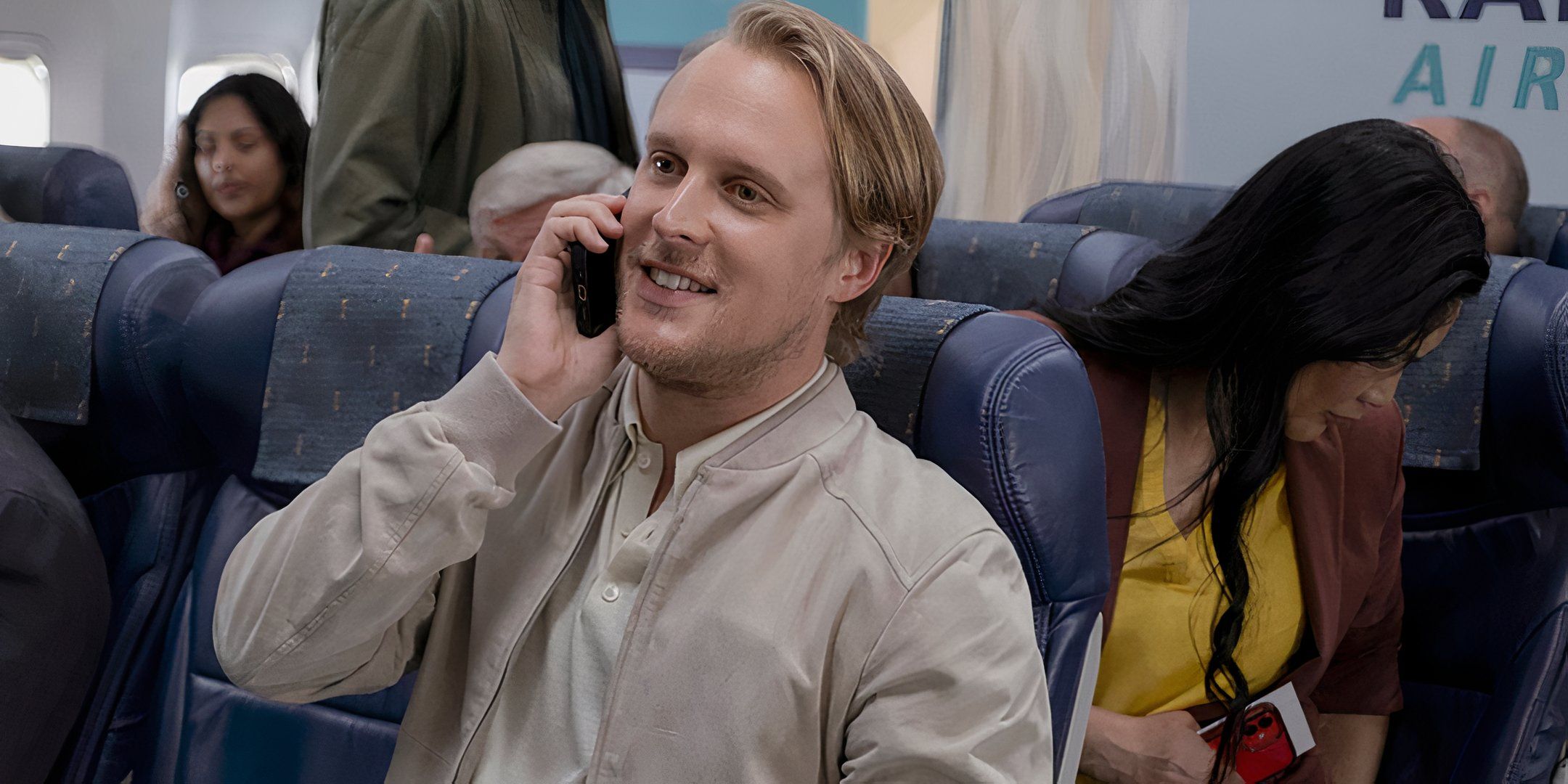 John Early as himself talking on the phone in an airplane in Laid