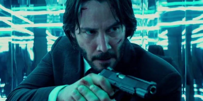 Keanu Reeves pointing a gun in the mirror maze in John Wick Chapter 2