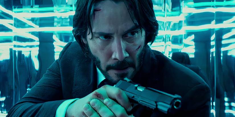 Keanu Reeves pointing a gun in the mirror maze in John Wick Chapter 2