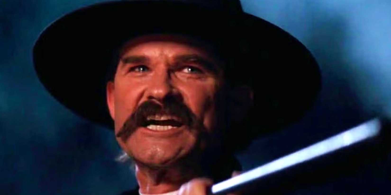 Kurt Russell holding a shotgun as Wyatt Earp in Tombstone