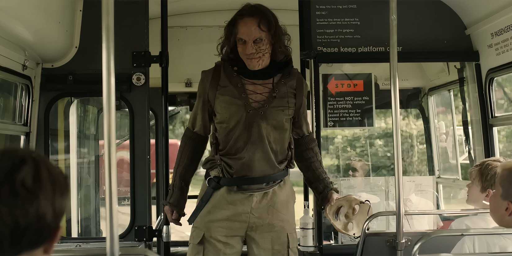 Martin Portlock's Peter smiling creepily while standing at the front of a school bus in Peter Pan's Neverland Nightmare