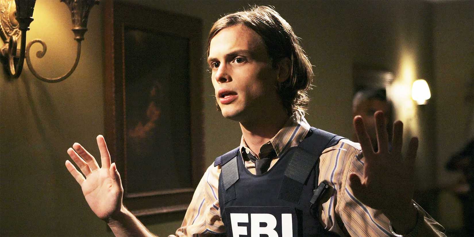 Matthew Gray Gubler as Spencer Reid in an FBI vest with hands up in Criminal Minds