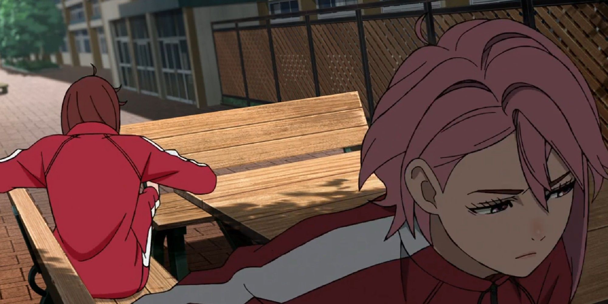 Momo and Aira sitting on a bench and looking away from each other