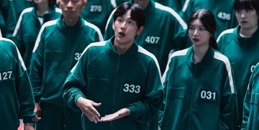 Myung-gi standing in a crowd and talking in Squid Game season 2