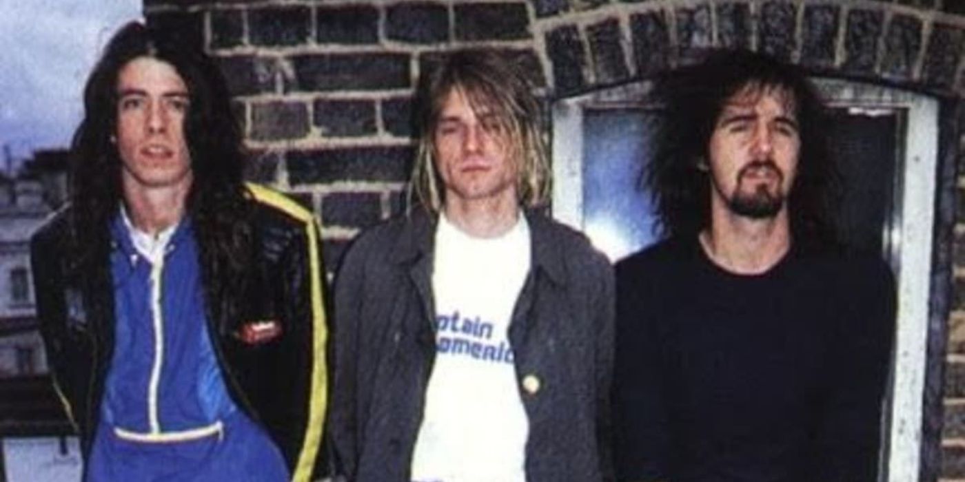 Nirvana encostado em uma parede de tijolos em When Nirvana Came to Britain.