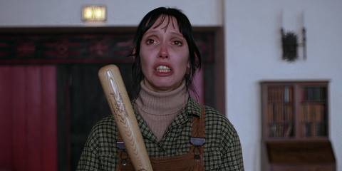 Shelley Duvall holding a bat and looking distraught as Wendy Torrance in The Shining
