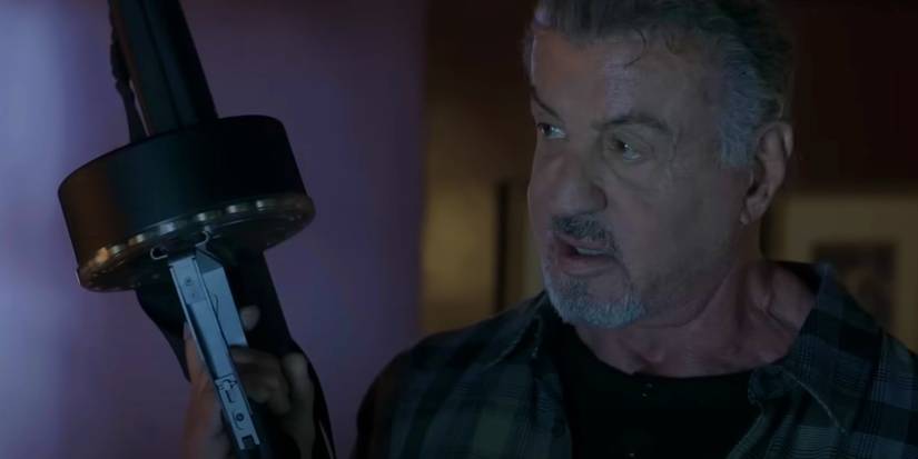 Sylvester Stallone as Chester holding an AA12 in Alarum