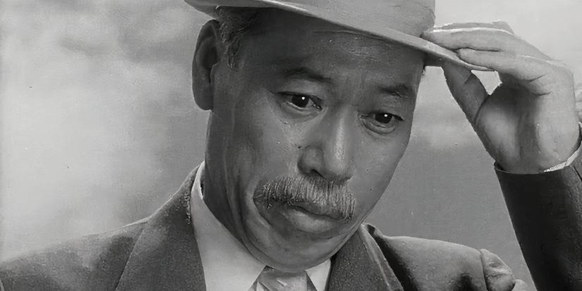 Takashi Shimura looking down and holding his hat in High and Low