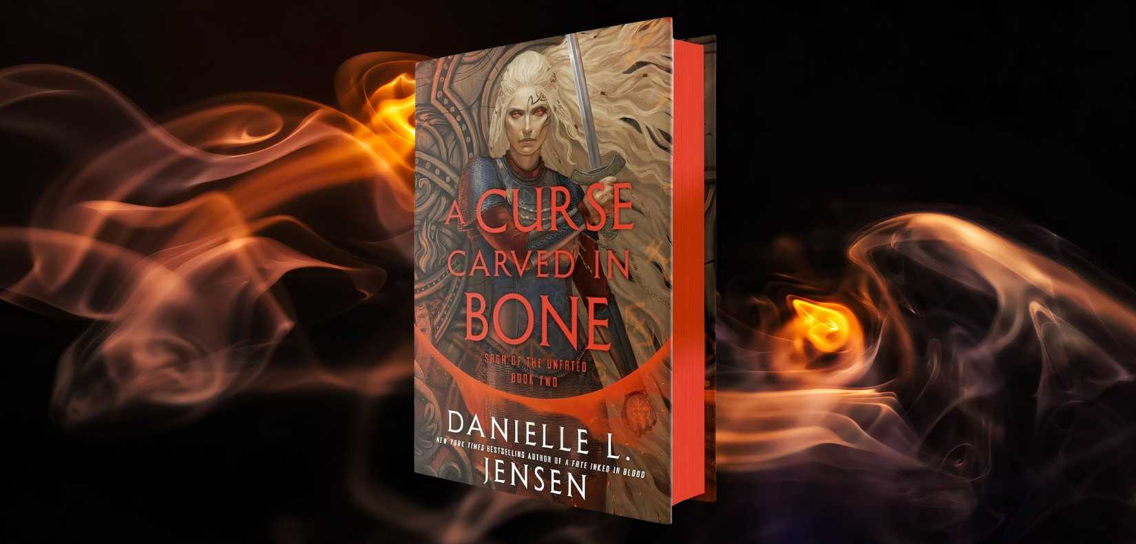 This image depicts the book cover for 'A Curse Carved In Bone' by Danielle L. Jensen on top of a custom background. The book cover is red and black and depicts a blonde woman holding a sword. The custom background is smokey fire on a black background.