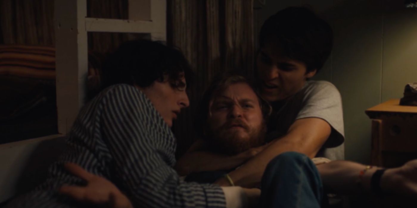 Finn Wolfhard and another boy tackling Fred Hechinger in Hell of a Summer