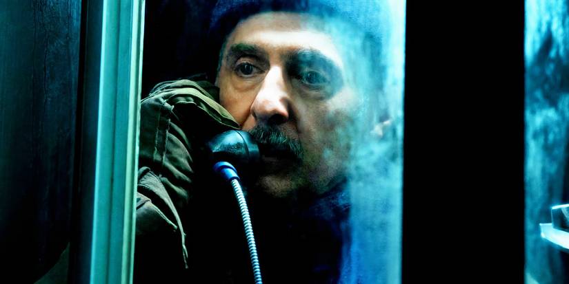 A man talking in a phone booth in Severance