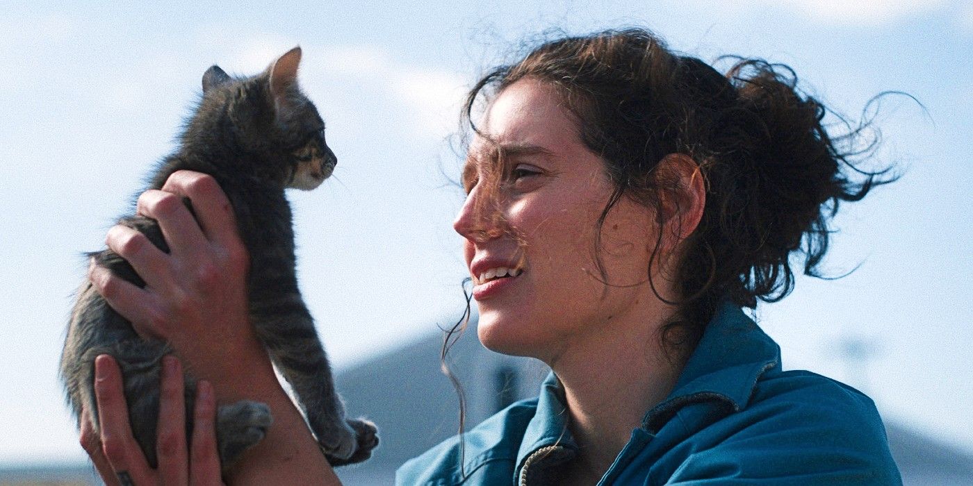 Agnes holding up a kitty she found in a parking lot to her face in Sorry, Baby