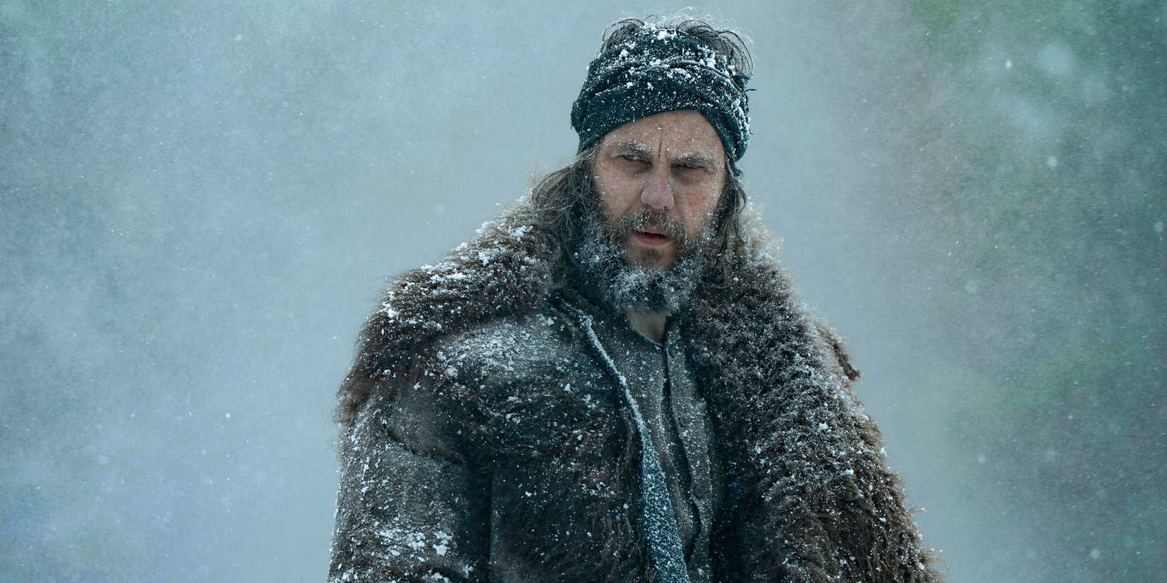 Taylor Kitsch's Isaac looking suspiciously while covered in snow in American Primeval