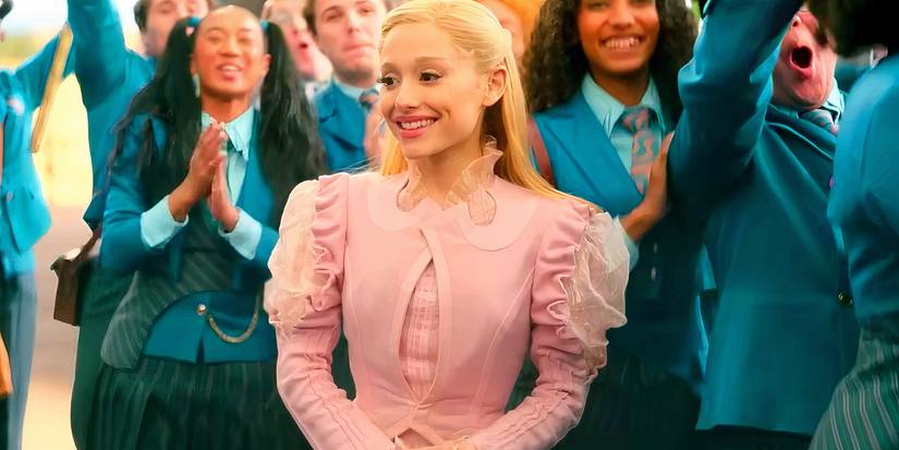 Ariana Grande Butera as Glinda smiling in a crowd of Shiz students in Wicked