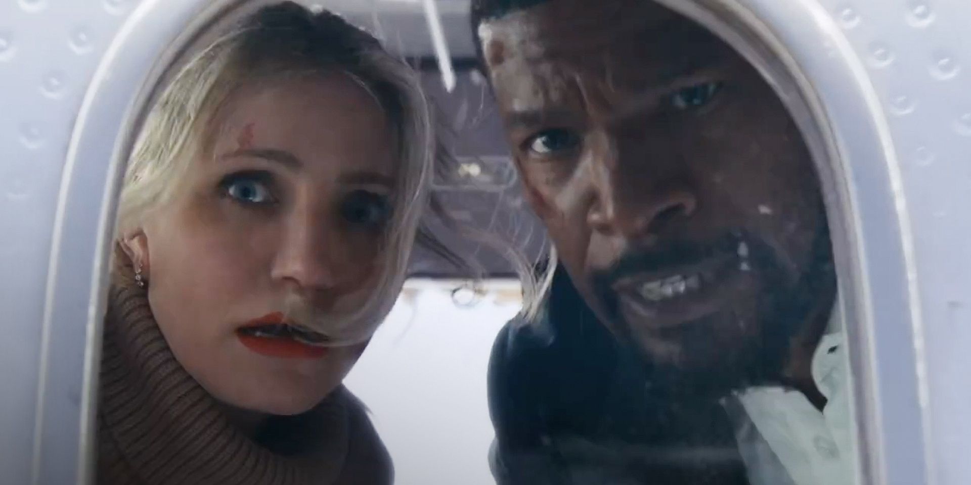 Emily (Cameron Diaz) and Matt (Jamie Foxx) looking out a plane window with alarmed expressions in Back in Action