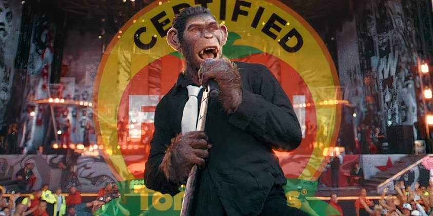 Robbie Williams as an ape singing in Better Man (2025) above an opaque Rotten Tomatoes logo