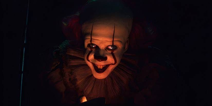 Bill Skarsgard as Pennywise smiling In IT