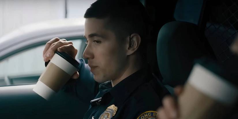 Alex Diaz sipping coffee while talking Officer Harmon in On Call