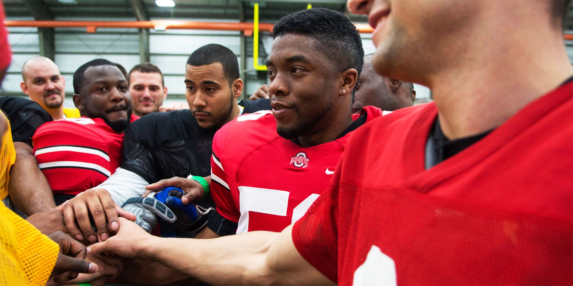 Chadwick Boseman as Vontae Mack, in uniform, shaking hands, on draft day